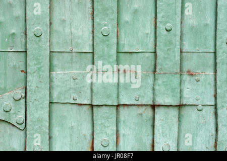 Gli sfondi e le texture: vecchia verniciato di verde metallico rivettato porta close-up shot Foto Stock