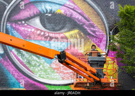 Artista Eduardo Kobra è raffigurato come egli lavora su un gigante di dimensioni John Lennon murale a Upfest 2017, il più grande d'Europa libera, street art & graffiti festival Foto Stock