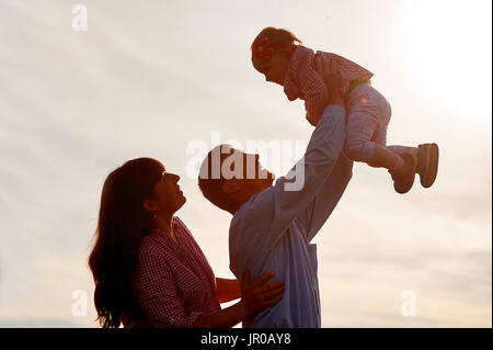 L uomo e la donna sollevare il bambino nelle braccia Foto Stock