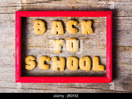 Si torna a scuola scritto con i cookie su un tavolo di legno Foto Stock