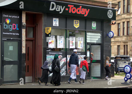 Famiglia asiatica rifugiato vestito Hijab sciarpa su strada nel Regno Unito scena quotidiana Govanhill Glasgow Foto Stock