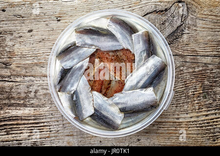 Ciotola di filetti di acciuga su sfondo di legno; vista superiore Foto Stock