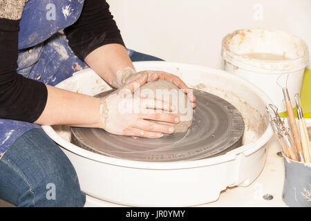 Potter femmina creando un vaso di terracotta su un Tornio del vasaio Foto Stock