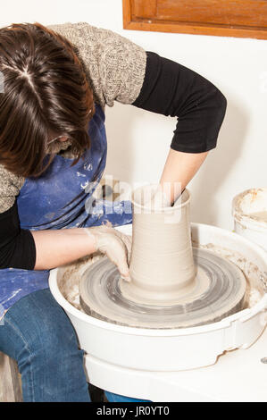 Potter femmina creando un vaso di terracotta su un Tornio del vasaio Foto Stock