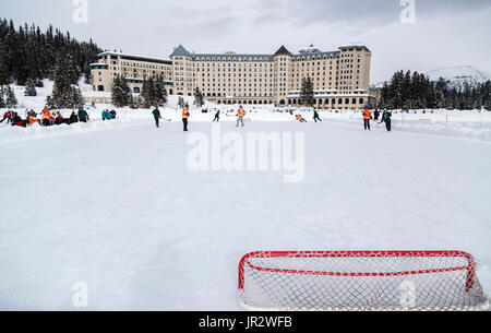 Una vista da dietro la rete di Hockey durante Un gioco di Hockey dello stagno in inverno sul lago ghiacciato Louise nel parco nazionale di Banff, contro... Foto Stock