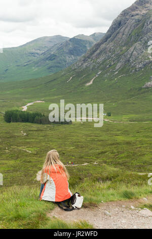 Glen Coe - giovane donna ammirando la vista di glencoe e il Buachaille Etive Mor da parte su del diavolo la scalinata, Glencoe, Scotland Regno Unito Foto Stock