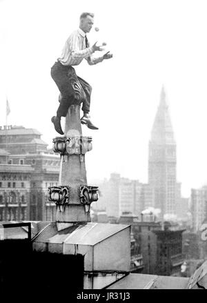 'Umano volare' Reynolds sul tetto di una decorazione in New York City. Giovanni "Jammie' Reynolds (nato 1890 o 91 - ?) era un americano il temerario. Poco è noto circa i primi anni di vita, che cosa è stato di lui una volta che ha smesso di eseguire o anche il suo vero nome. Un acrobata e giocoliere, egli è conosciuto da molti nomi - Daredevil Johnny, Daredevil Jack, la meraviglia di arrampicata, la lucertola, l'Uomo ragno, e il volo umano. Un articolo di giornale da 1922 precedenti ha iniziato ad esibirsi all'età di sei anni in Buffalo, in equilibrio su un piede da un pennone 140 piedi in aria. Il suo primo grande stunt è venuto all'età 12 quando è salito fino al lato Foto Stock