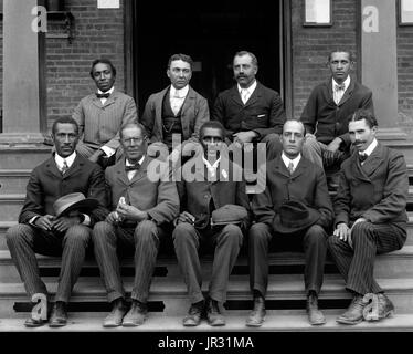 Carver, seduto sui gradini con il personale dell'istituto di Tuskegee. George Washington Carver (1864 - Gennaio 5, 1943) era un afro-americano di scienziato, botanico, educatore e inventore nato in schiavitù. Nel 1891 ha frequentato e studiato botanica alla Iowa State Agricultural College dove egli fu il primo studente nero e in seguito ha insegnato come il primo nero membro della facoltà. La sua reputazione si basa sulla sua ricerca e promozione di colture alternative per il cotone, come arachidi, semi di soia e patate dolci, che ha anche aiutato la nutrizione per le famiglie contadine. Egli ha voluto che gli agricoltori poveri di colture alternative sia Foto Stock