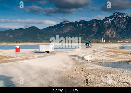 Vista del svuotato Forggensee con cassone ribaltabile, auto e wc casa a Füssen in Baviera. Foto Stock