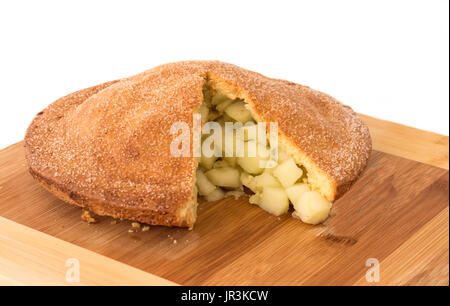 Pane appena sfornato la torta di mele con fetta rimossa esponendo frutta sul tagliere di legno Foto Stock