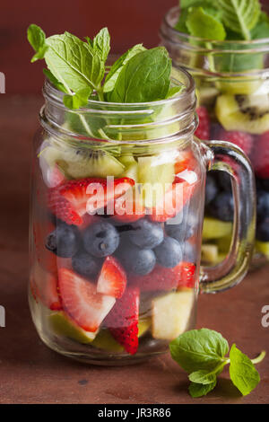 Insalata di frutta in mason jar Mirtillo Fragola kiwi menta apple Foto Stock