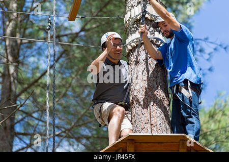 MEZIO, Portogallo - 22 luglio 2017: uomo avventuroso si prepara a una diapositiva in zip fodera attraverso la foresta. Luglio 22, 2017, Mezio, Portogallo. Foto Stock