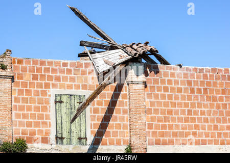 Tetto in tegole danneggiato e che necessitano di riparazione . cielo blu Foto Stock