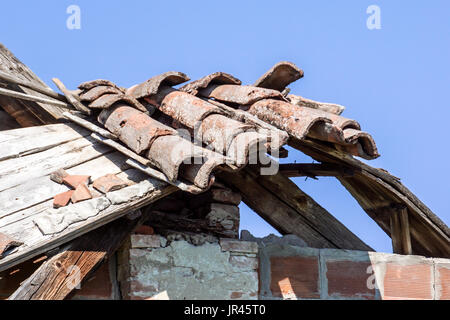 Tetto in tegole danneggiato e che necessitano di riparazione . cielo blu Foto Stock