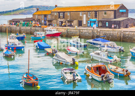 Le barche nel porto e gli edifici sul Cobb, acquario marino e la pesca e barcaiolo's College, a Lyme Regis, Dorset in luglio - effetto hdr Foto Stock