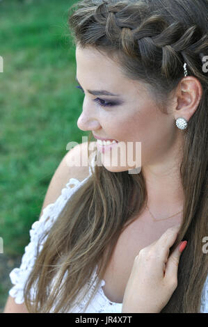 Close-up ritratto di giovane donna elegante sul prato verde sullo sfondo Foto Stock