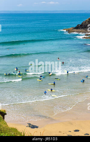 Scuola di surf con persone di imparare a navigare a Poldhu Cove Beach, Cornwall, Regno Unito Foto Stock