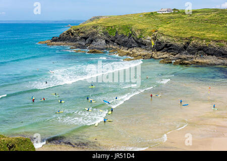 Poldhu Cove Beach con surfers imparare a navigare, Cornwall, Regno Unito Foto Stock