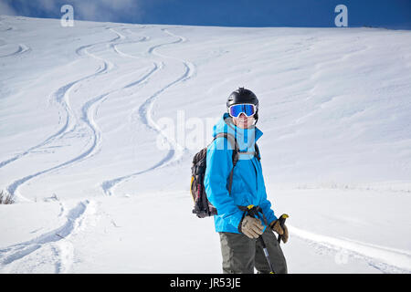 Backcountry rider con sorriso con nuove tracce in background Foto Stock