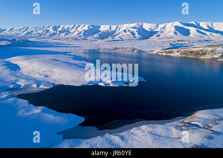 Falls Dam e Gamma Hawkdun in inverno, Maniototo di Central Otago, South Island, in Nuova Zelanda - antenna fuco Foto Stock