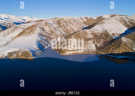 Ghiaccio in corrispondenza del bordo della Falls Dam in inverno, Maniototo di Central Otago, South Island, in Nuova Zelanda - antenna fuco Foto Stock