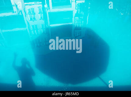 Ombra di un uomo e di un ombrello sul fondo di una piscina Foto Stock