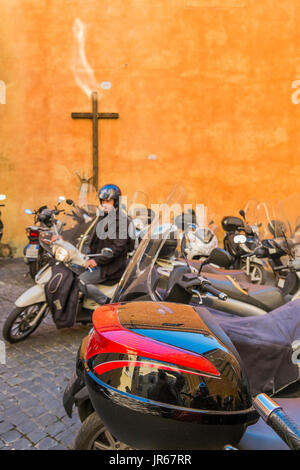 Roman scooter parcheggiati in un cantiere con una croce sulla parete posteriore, Roma, lazio, Italy Foto Stock