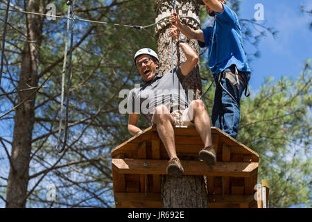 MEZIO, Portogallo - 22 luglio 2017: uomo avventuroso si prepara a una diapositiva in zip fodera attraverso la foresta. Luglio 22, 2017, Mezio, Portogallo. Foto Stock