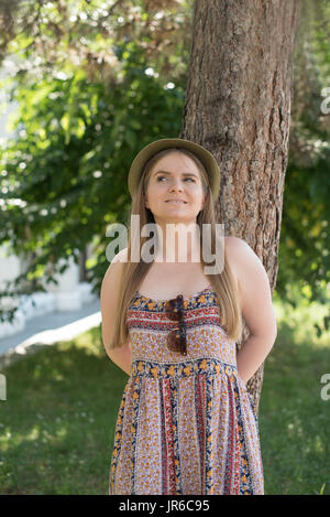 Ritratto di una donna sorridente appoggiato a un albero Foto Stock