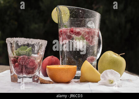 Brocca e bicchiere di acqua con frutta fresca Foto Stock