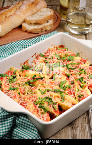 Pasta conchiglioni gusci di carne ripieni di carne macinata con spinaci e salsa di pomodoro , formaggio parmigiano. Foto Stock