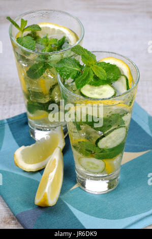 Un cocktail rinfrescante cetriolo mojito con le fette di limone e menta Foto Stock