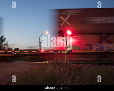 Maple Creek, Saskatchewan, Canada. 26 Ago, 2016. Un treno merci viaggiano su Canadian Pacific Railway's mainline velocità attraverso un passaggio a livello sulle praterie canadesi. Credito: Bayne Stanley/ZUMA filo/Alamy Live News Foto Stock