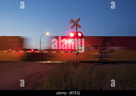 Maple Creek, Saskatchewan, Canada. 26 Ago, 2016. Un treno merci viaggiano su Canadian Pacific Railway's mainline velocità attraverso un passaggio a livello sulle praterie canadesi. Credito: Bayne Stanley/ZUMA filo/Alamy Live News Foto Stock