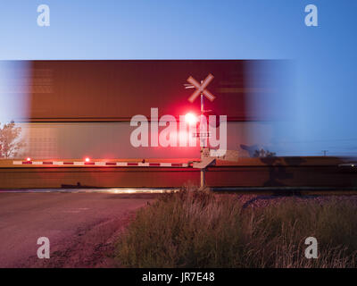 Maple Creek, Saskatchewan, Canada. 26 Ago, 2016. Un treno merci viaggiano su Canadian Pacific Railway's mainline velocità attraverso un passaggio a livello sulle praterie canadesi. Credito: Bayne Stanley/ZUMA filo/Alamy Live News Foto Stock