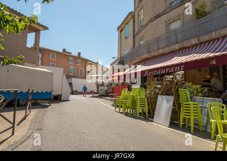 Sablet, Provence Alpes Côte d'Azur, in Francia. 4 agosto 2017. Il medievale di vinificazione del villaggio Sablet ospita 5 giorni di fiera Votive annualmente ai primi di agosto. Fervono i preparativi per la partenza della fiera a temperature di 40 gradi a metà pomeriggio con la canicola europea che influenzano questa area del Mediterraneo del sud est della Francia. La fiera corre da 09.00am fino a mezzanotte ogni giorno. I tavoli e le sedie sono impostati sulla strada principale al di fuori del villaggio Cafe du Sport per l'evento. Credito: Malcolm Park/Alamy Live News Foto Stock