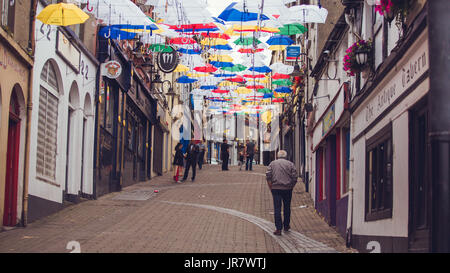 La gente a piedi attraverso la strada di Enniscorthy Irlanda decorate con ombrelloni flottante per il rockin' food festival Foto Stock