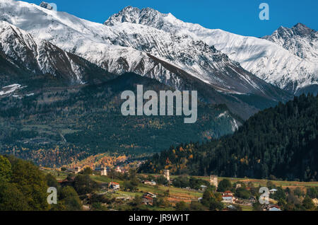 Vista delle torri Svanetian nel villaggio di Mestia contro le montagne con ghiacciai picchi innevati. Svaneti superiore, Georgia. Punto di riferimento georgiana Foto Stock