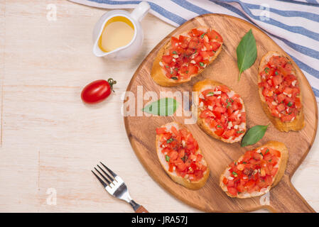 Italian bruschetta con arrosti di pomodori, mozzarella e erbe su un foglio di carta Foto Stock