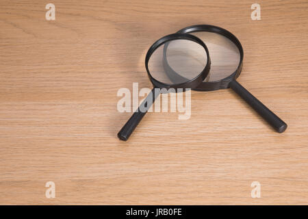 Due lenti di ingrandimento giacente sul tavolo di legno Foto Stock