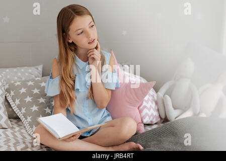 Curioso schoolgirl pensando a qualcosa di Foto Stock
