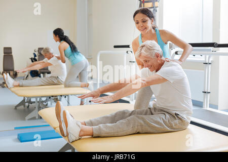 Positivo il pensionamento felice facendo esercizi di stretching Foto Stock