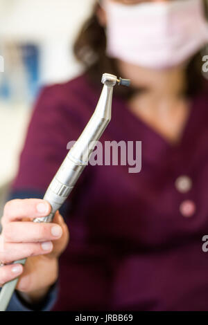 Igienista dentale dimostrando manipolo con coppa di gomma per la lucidatura dei denti Foto Stock