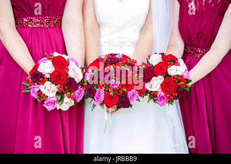 Sposa con bridesmaids holding bouquet nuziali Foto Stock
