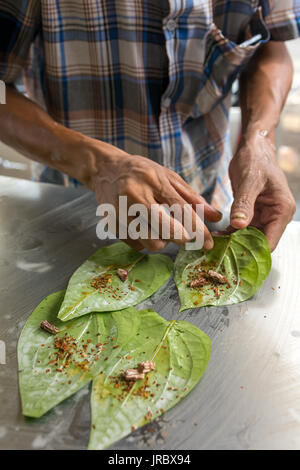 Uomo che fa di betel dado sulla bancarella di strada in Myanmar (Birmania). Foto Stock