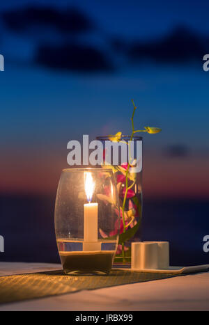 Candela su un tavolo in vista tramonto ristorante su Koh Kood island, Thailandia Foto Stock