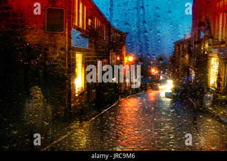 Guardando attraverso una finestra Misty con gocce di pioggia a Main Street Haworth West Yorkshire al tempo di Natale Foto Stock