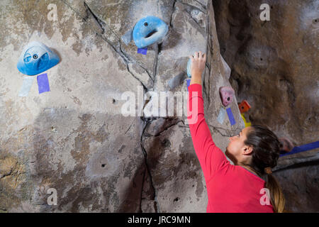 Determinata la donna pratica di arrampicata in palestra per il fitness Foto Stock