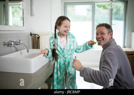 Ritratto di sorridere padre e figlia spazzolare i denti in bagno a casa Foto Stock