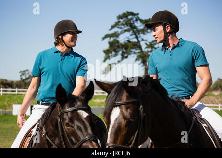 Due maschio fantini a cavallo in un ranch in una giornata di sole Foto Stock